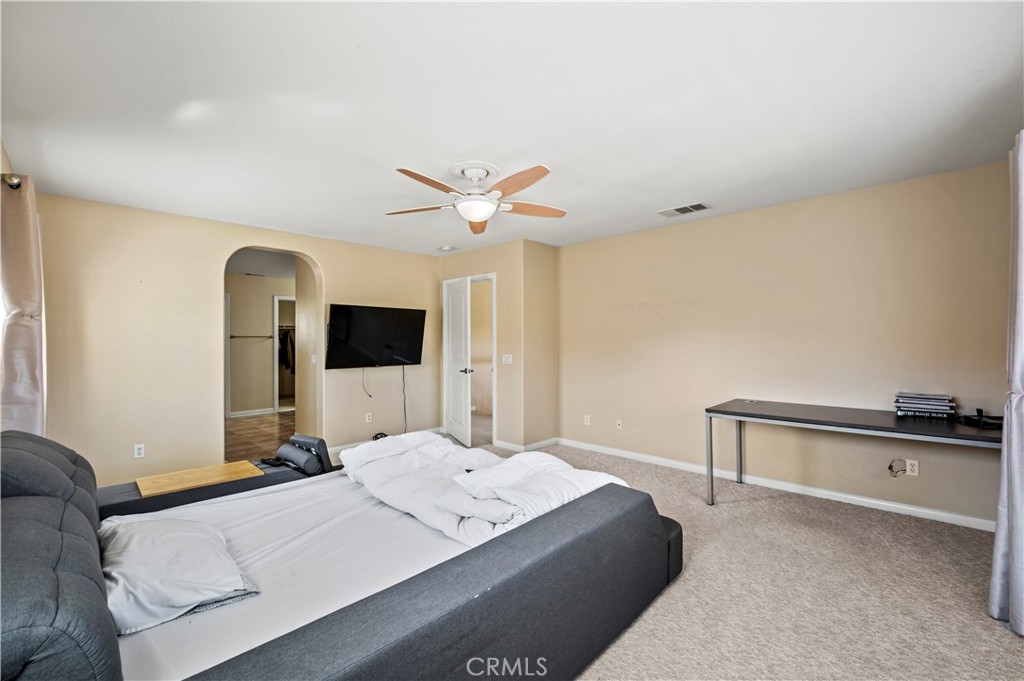 12810 Sierra Creek Drive Riverside, CA 92503 - Photo 31 of 52 a bedroom with a large bed and a chandelier