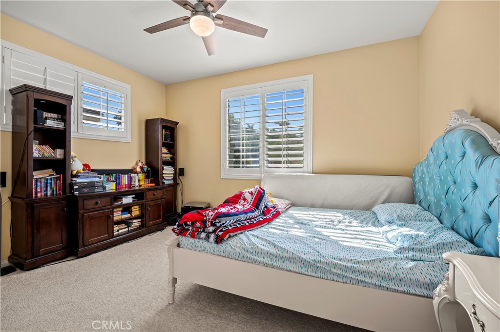 12810 Sierra Creek Drive Riverside, CA 92503 - Photo 38 of 52 a bedroom with a bed and a chandelier