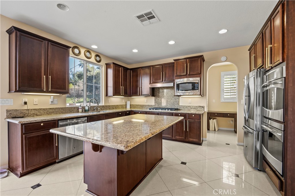 12810 Sierra Creek Drive Riverside, CA 92503 - Photo 42 of 52 a kitchen with stainless steel appliances granite countertop a sink stove and refrigerator