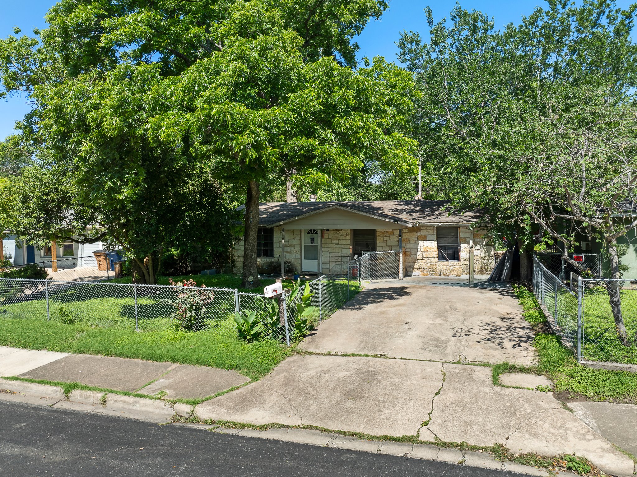 1122 Spur Street, Unit D Austin, TX 78721 - Photo 1 of 6 Single-story residence featuring a stone-clad facade and a concrete driveway
