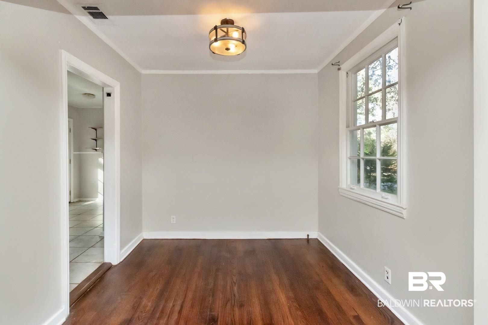 5001 Hillwood Circle South Mobile, AL 36608 - Photo 4 of 20 Spare room with ornamental molding, visible vents, baseboards, and wood finished floors