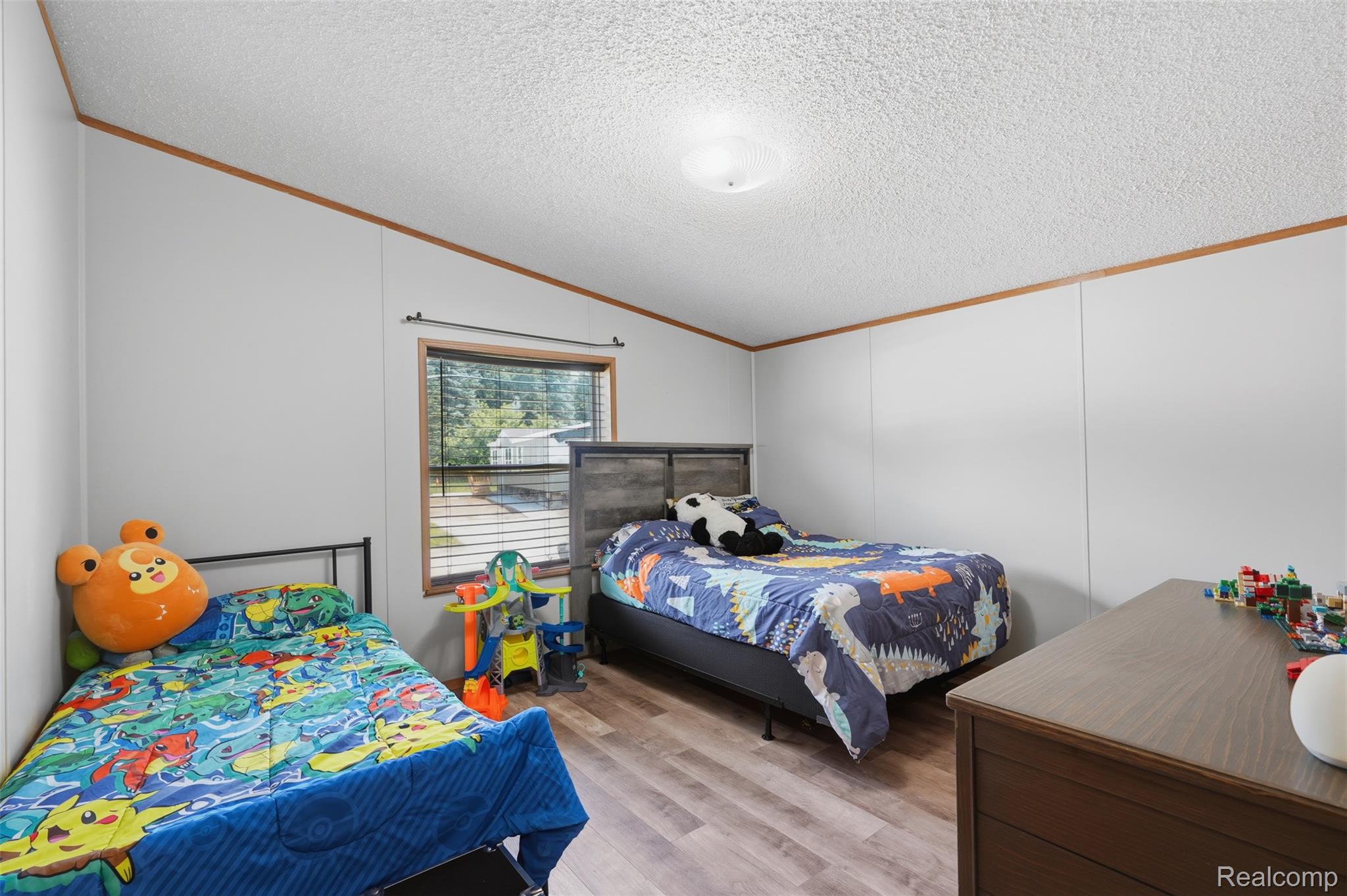 4634 Butternut Street Clarkston, MI 48348 - Photo 19 of 28 Room featuring wood-finish flooring, white panel walls with wood trim, and a window with horizontal blinds