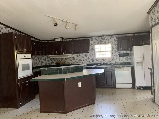 a kitchen with stainless steel appliances granite countertop a stove a refrigerator a sink and dishwasher