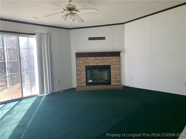 a view of an empty room with a fireplace and a window