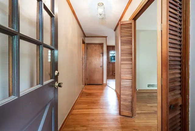 a view of a hallway with wooden floor and staircase