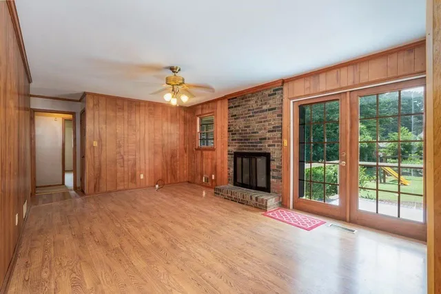 a view of an empty room with a fireplace and a window