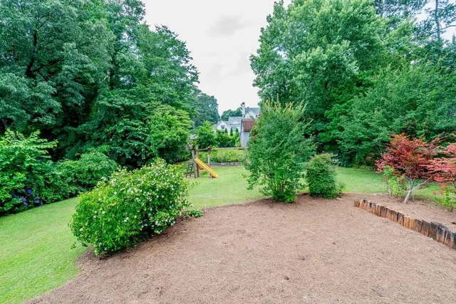a view of a road with plants and trees beside of it