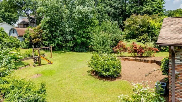 a view of swimming pool with lawn chairs and plants