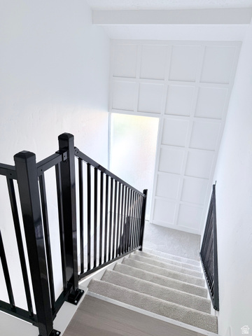 227 South West Lane Provo, UT 84601 - Photo 18 of 25 Staircase featuring dark metal railings and light-colored carpeted treads with wood-finish risers