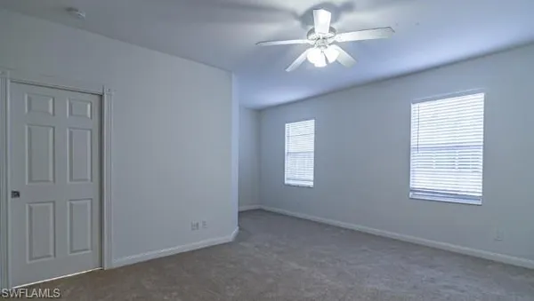 a view of an empty room with a chandelier fan