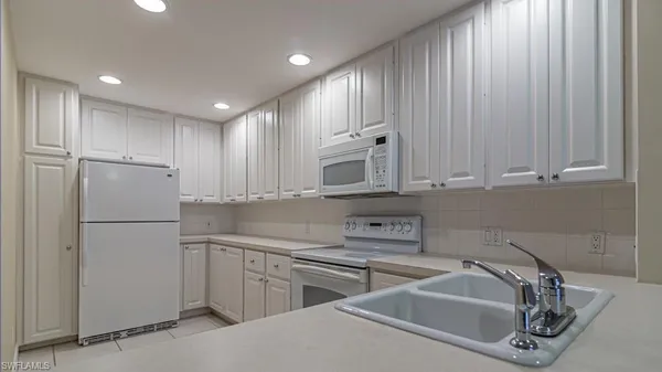 a kitchen that has a sink and a stove in it