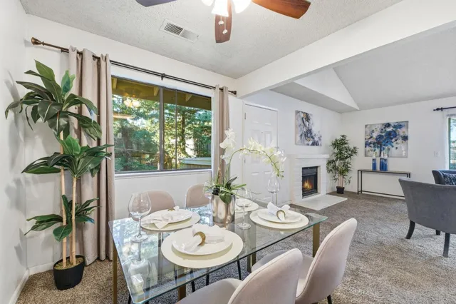 a dining room with furniture potted plants and wooden floor