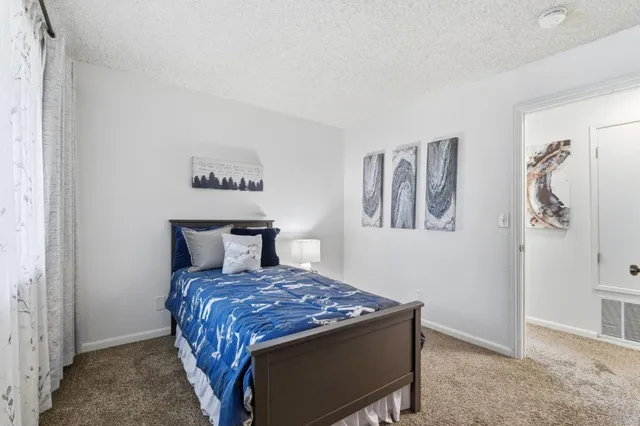 a bed sitting in a bedroom next to a bathroom
