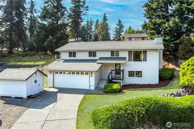 an aerial view of a residential house with a yard and garden