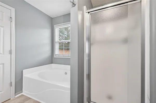 a white bath tub sitting next to a shower