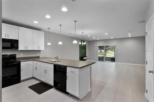 a kitchen with a sink a refrigerator and cabinets