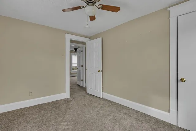 an empty room with a fan and a ceiling fan