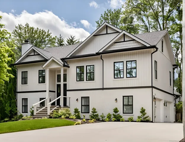 a view of a white house with large windows and a small yard