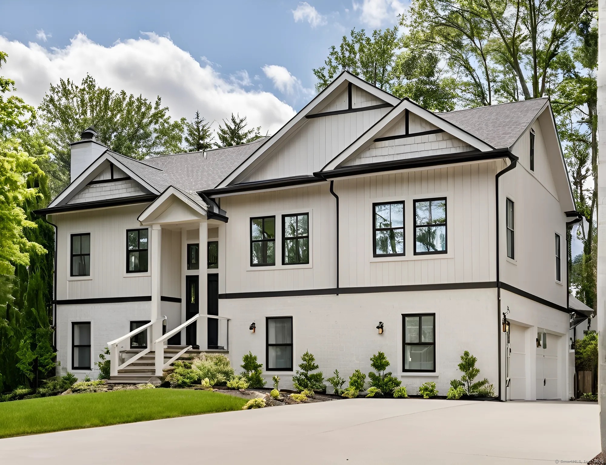a view of a white house with large windows and a small yard