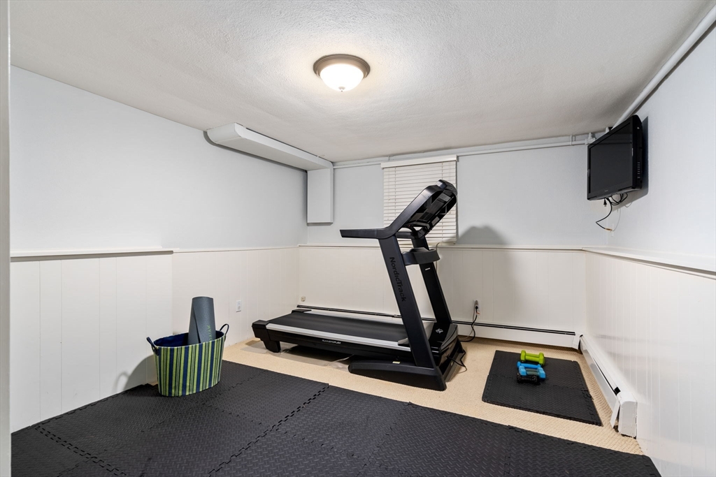 81 Woodfall Road Belmont, MA 02478 - Photo 28 of 37 a room with gym equipment and wooden floor