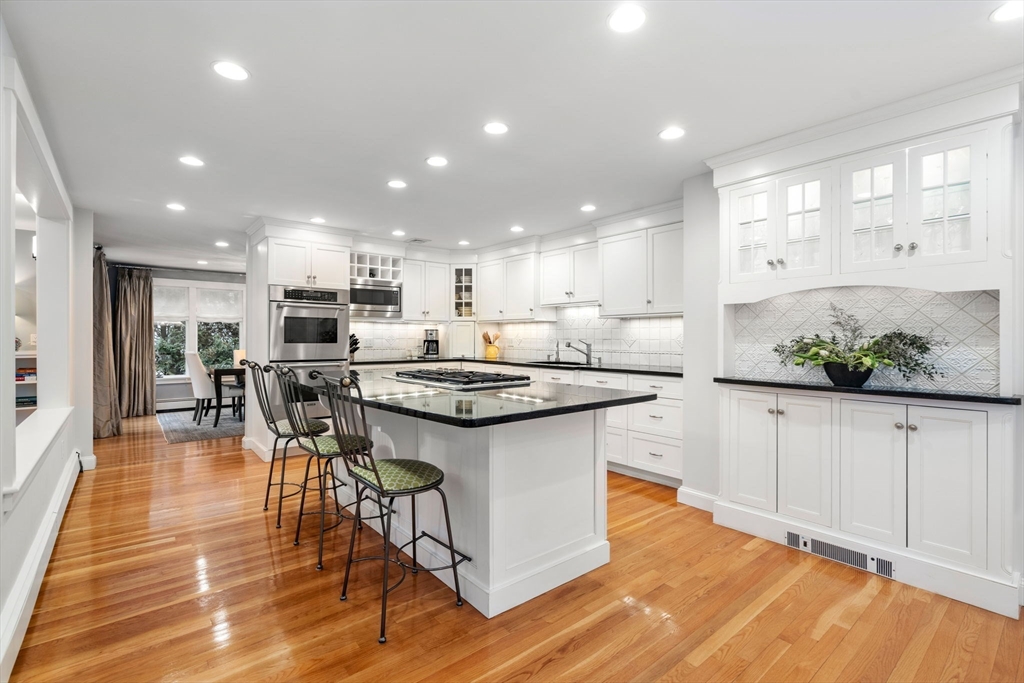 81 Woodfall Road Belmont, MA 02478 - Photo 7 of 37 a kitchen with stainless steel appliances granite countertop a table chairs stove and white cabinets