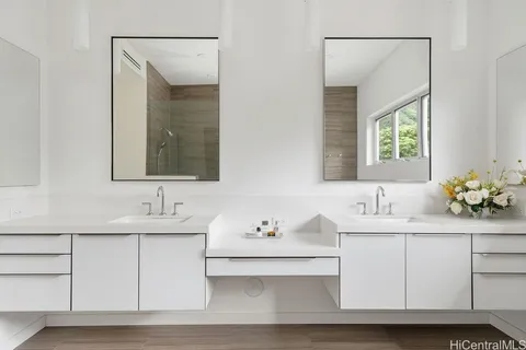 a bathroom with double vanity sinks and a mirror