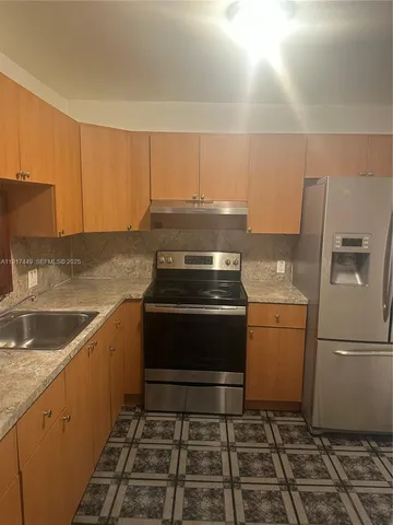 a kitchen with a stove and a refrigerator