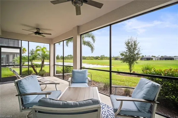 a living room with furniture and a floor to ceiling window