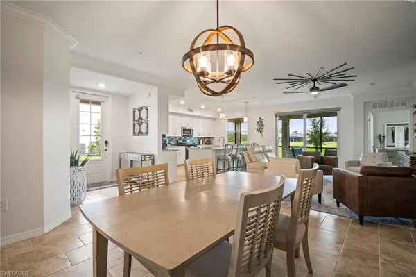 a dining room with wooden floor a chandelier a wooden table and chairs