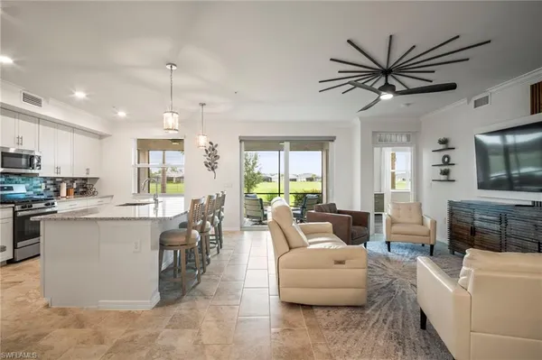 a living room with kitchen island furniture and a flat screen tv