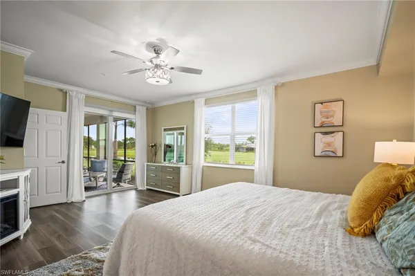 a bedroom with a large bed and a flat tv screen on dresser
