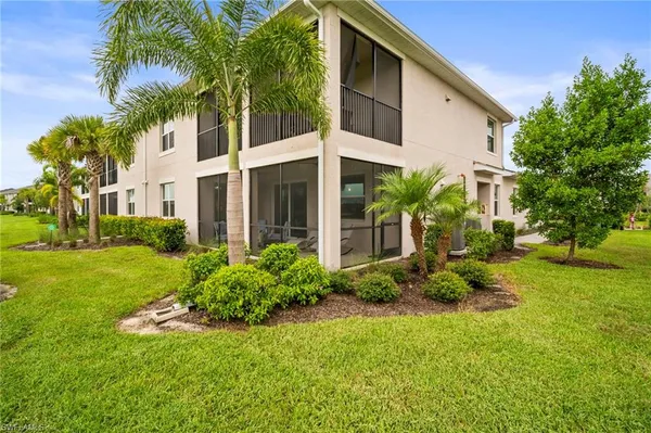 a view of a house with a yard and potted plants