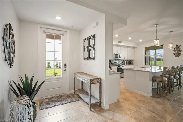 a kitchen with stainless steel appliances kitchen island granite countertop a refrigerator and a sink