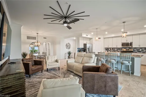 a living room with furniture and a view of kitchen