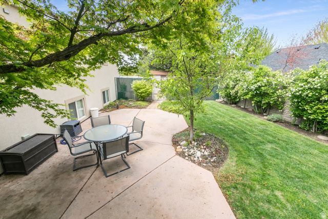 10183 Hickory Point Drive Sandy, UT 84092 - Photo 32 of 36 Expansive concrete patio with mature tree coverage, manicured lawn, and established perimeter plantings