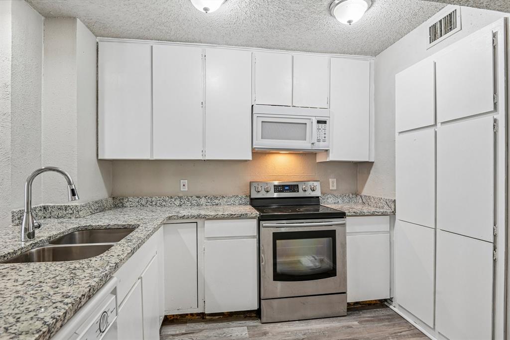 5534 Boca Raton Boulevard, Unit 292 Fort Worth, TX 76112 - Photo 9 of 31 a kitchen with granite countertop white cabinets and white appliances
