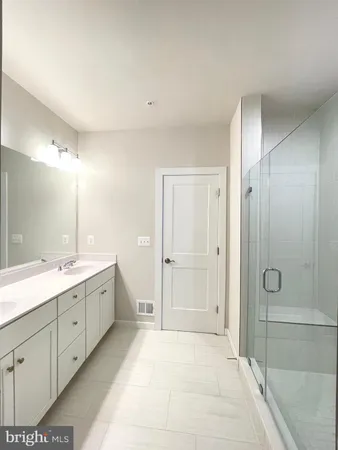 a spacious bathroom with a double vanity sink mirror and shower