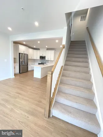 a view of a hallway with wooden floor and staircase