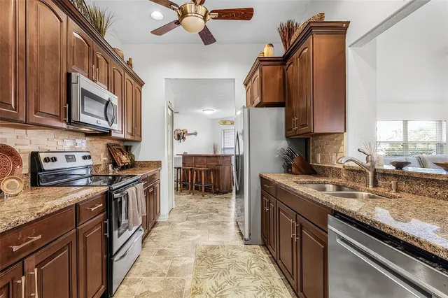 a kitchen with stainless steel appliances granite countertop a sink stove and cabinets