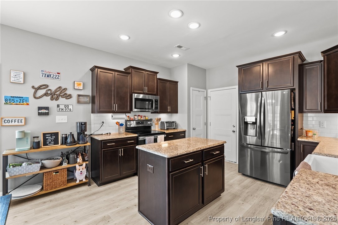 6438 Calloway Road Aberdeen, NC 28315 - Photo 12 of 50 a kitchen with stainless steel appliances granite countertop a stove a refrigerator and a refrigerator