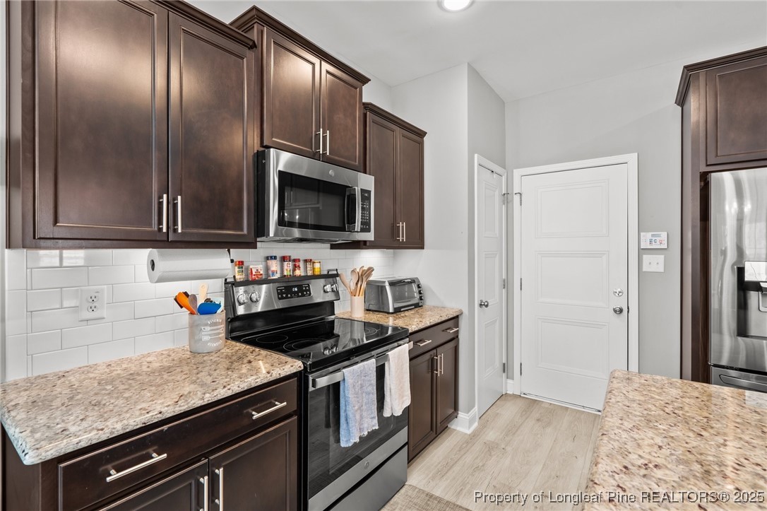 6438 Calloway Road Aberdeen, NC 28315 - Photo 15 of 50 a kitchen with stainless steel appliances granite countertop a stove a refrigerator and a sink