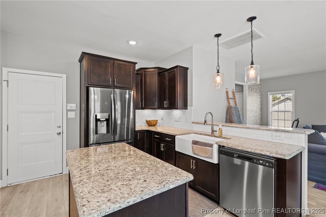 6438 Calloway Road Aberdeen, NC 28315 - Photo 16 of 50 a kitchen with stainless steel appliances granite countertop a sink stove and refrigerator