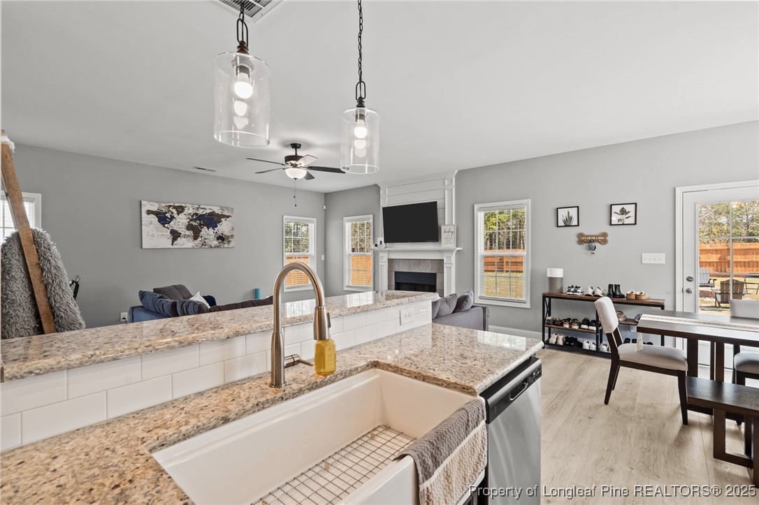 6438 Calloway Road Aberdeen, NC 28315 - Photo 17 of 50 a kitchen with a stove a center island a dining table and chairs with wooden floor