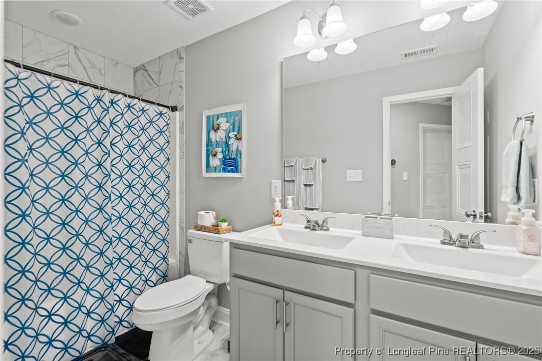 6438 Calloway Road Aberdeen, NC 28315 - Photo 26 of 50 a bathroom with a sink a toilet and a mirror