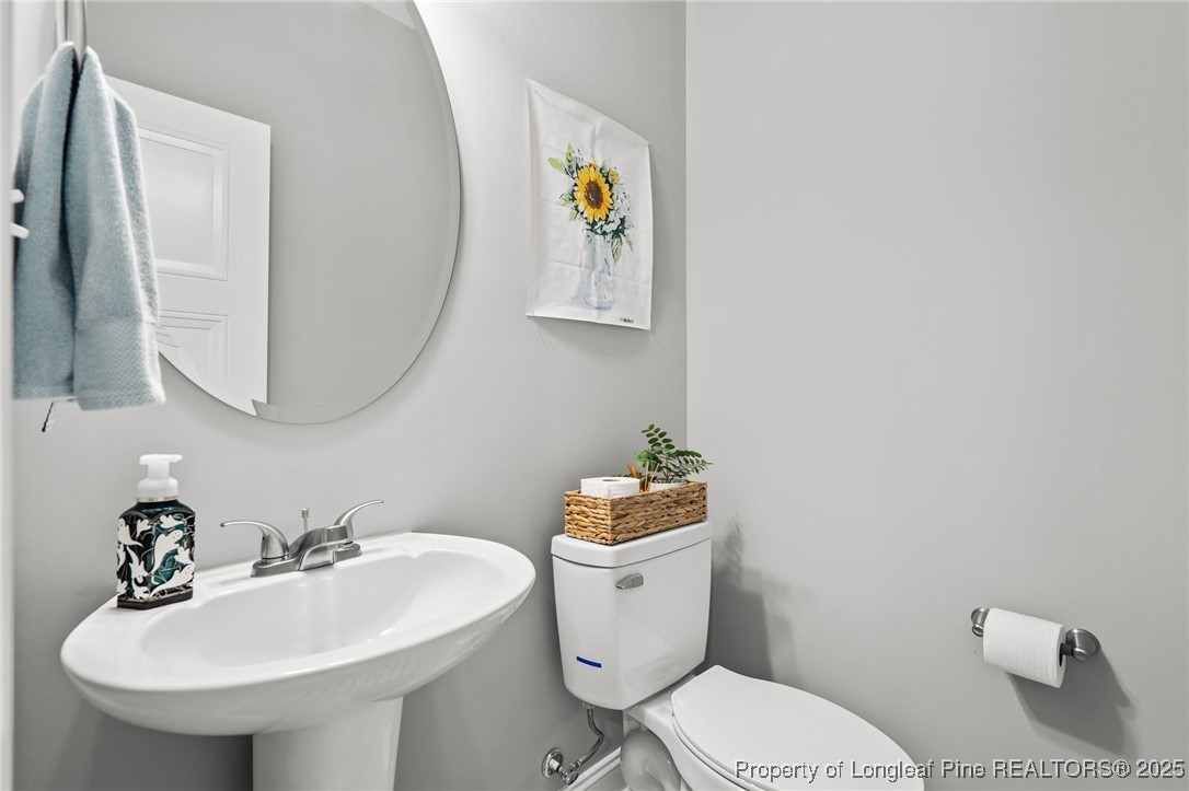 6438 Calloway Road Aberdeen, NC 28315 - Photo 8 of 50 a bathroom with a toilet a sink and mirror