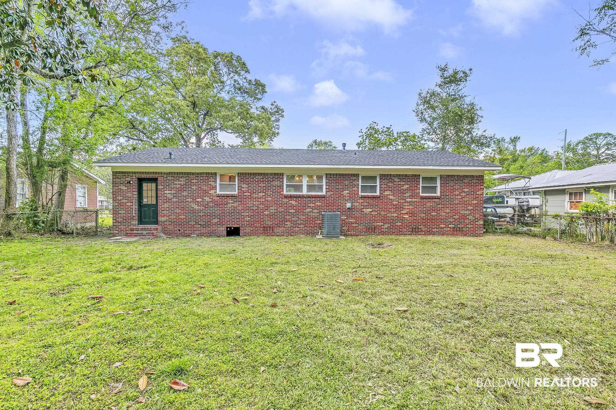 203 Anderson Road Saraland, AL 36571 - Photo 34 of 48 Back of property featuring brick siding, fence, central AC unit, and a lawn