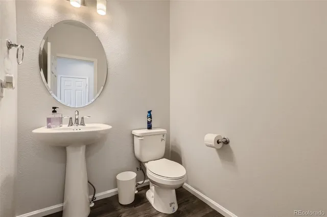 a bathroom with a toilet a sink and mirror