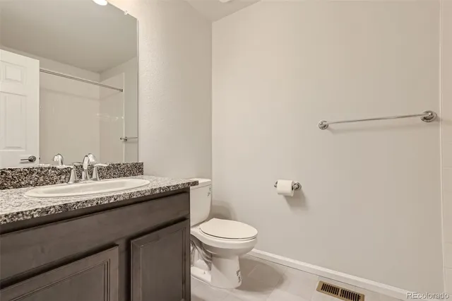 a bathroom with a granite countertop sink a toilet and a mirror