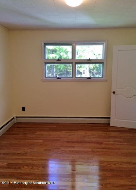 374 Maple Lake Road Moscow, PA 18444 - Photo 14 of 36 an empty room with wooden floor and windows
