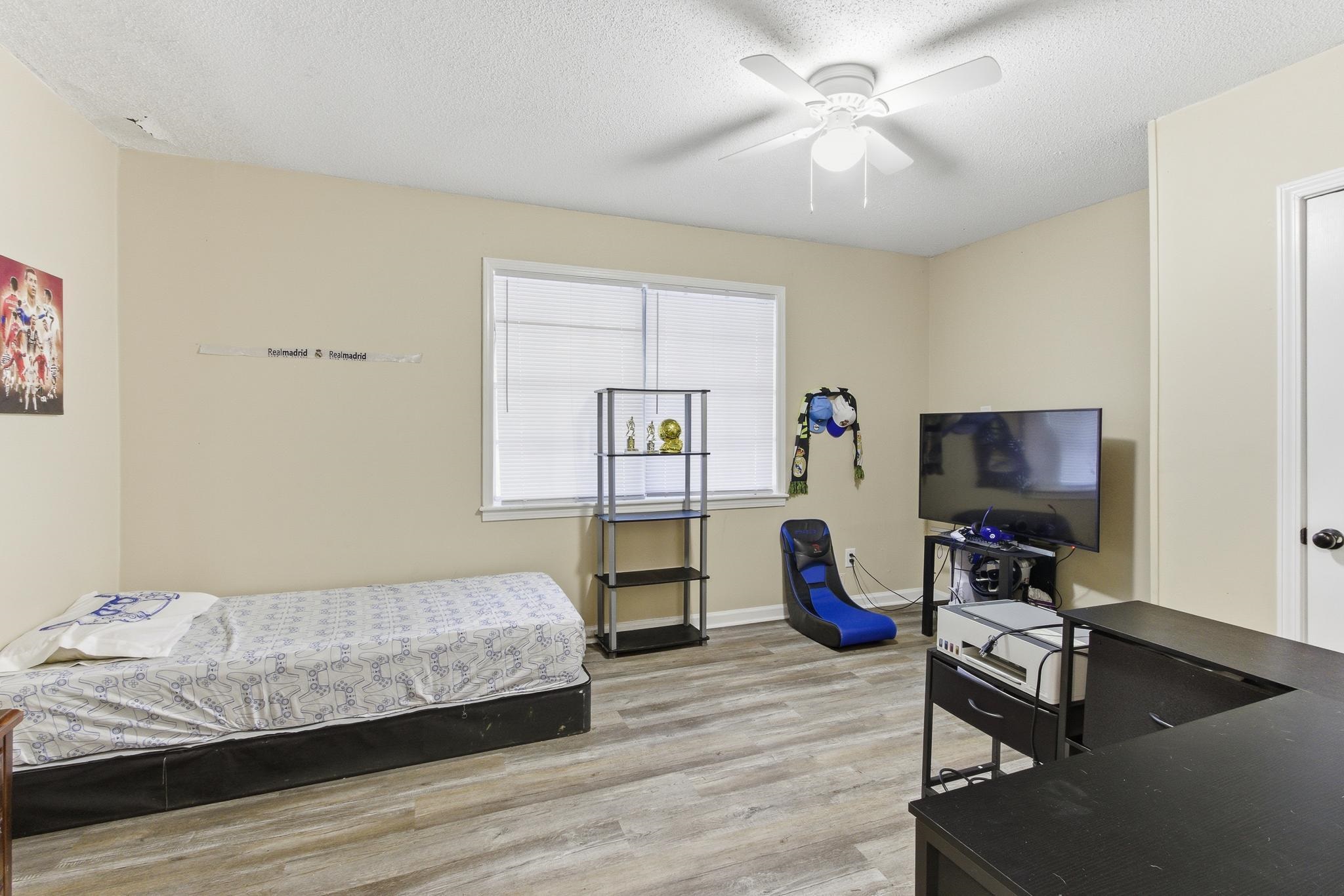5002 Benjestown Road Memphis, TN 38127 - Photo 22 of 29 Bedroom featuring light wood finished floors, a ceiling fan, and a textured ceiling